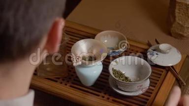 茶师从水壶往盖湾倒热水。 从热杯中蒸出来。 绿茶